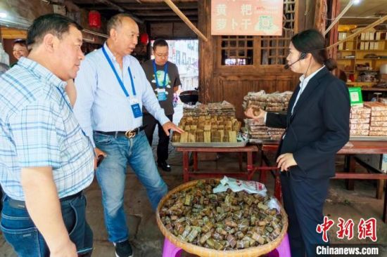 泸州尧坝古镇名小吃黄粑吸引海外华文媒体代表。记者 刘忠俊 摄 泸州尧坝古镇名小吃黄粑吸引海外华文媒体代表。记者 刘忠俊 摄