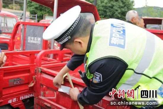 民警为村民们的车辆粘贴反光贴。 绵阳公安交警直属三大队供图 民警为村民们的车辆粘贴反光贴。 绵阳公安交警直属三大队供图