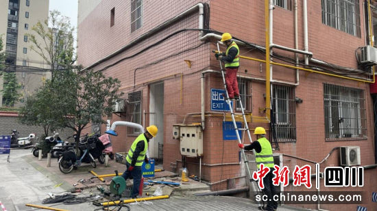工作人员正在进行墙面燃气管道的改造。刘倩 摄 工作人员正在进行墙面燃气管道的改造。刘倩 摄