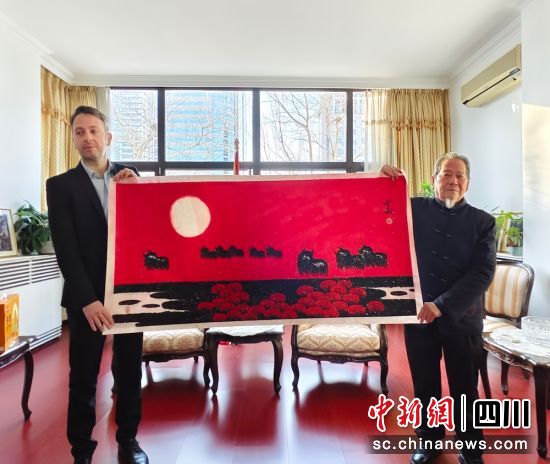 贾雨(右)向北马其顿共和国驻华大使馆捐赠画作。贾雨 供图 贾雨(右)向北马其顿共和国驻华大使馆捐赠画作。贾雨 供图