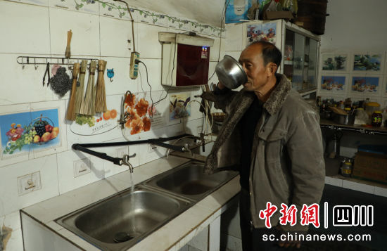 两合村村民李中华开心地喝着自来水。长宁县融媒体中心供图。 两合村村民李中华开心地喝着自来水。长宁县融媒体中心供图。