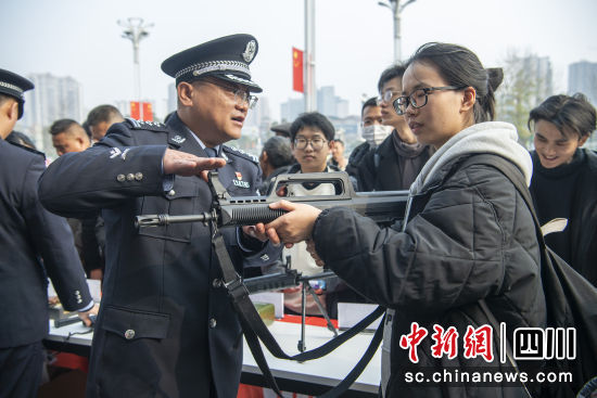 民警向旅客讲解警用枪支。张舒摄 民警向旅客讲解警用枪支。张舒摄