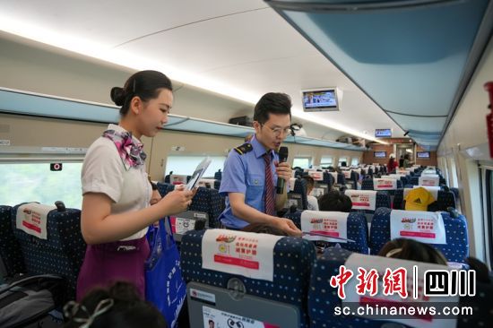 动车上宣传小分队与旅客进行“爱路护路”知识问答互动。费思童 摄 动车上宣传小分队与旅客进行“爱路护路”知识问答互动。费思童 摄