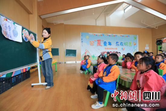 老师用普通话指导小朋友学习填图案。记者王磊摄 老师用普通话指导小朋友学习填图案。记者王磊摄