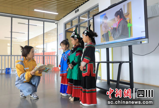 老师在指导小朋友学习普通话播报。记者 王磊 摄 老师在指导小朋友学习普通话播报。记者 王磊 摄