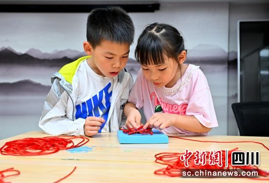 孩子们正在制作“中国结”。潘帅 摄 孩子们正在制作“中国结”。潘帅 摄