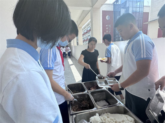 桑玉艳帮学生们打饭。青羊区教育局供图 桑玉艳帮学生们打饭。青羊区教育局供图