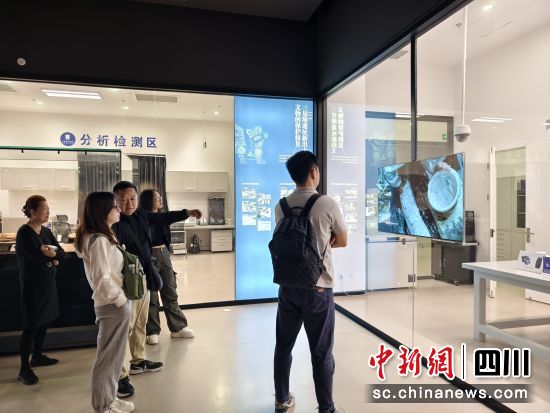 　　游客驻足观看文物修复过程，了解文物保护背后的故事。 德阳日报社供图