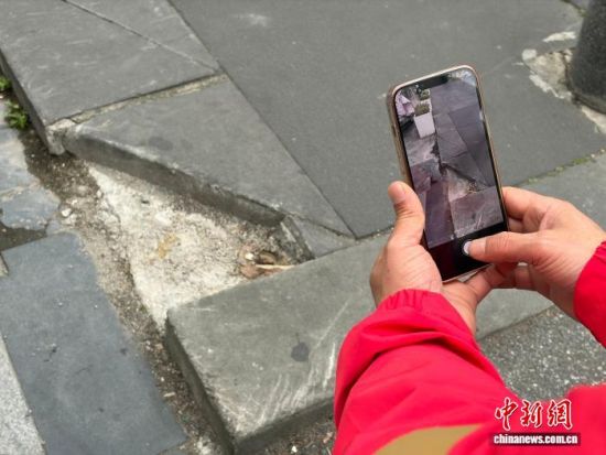 田师傅在拍摄路面砖石缺失。成都市城管委供图 田师傅在拍摄路面砖石缺失。成都市城管委供图