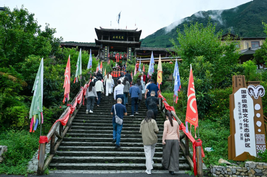 游客正在体验石椅村羌族入寨仪式。 摄/刘忠俊 游客正在体验石椅村羌族入寨仪式。 摄/刘忠俊