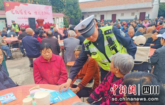 民警向老人发放交通安全宣传资料。 绵阳交警三大队供图 民警向老人发放交通安全宣传资料。 绵阳交警三大队供图