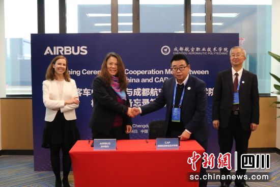 在刘建超和克里斯蒂娜见证下,何龙与宁斐签约。成都航院供图 在刘建超和克里斯蒂娜见证下,何龙与宁斐签约。成都航院供图