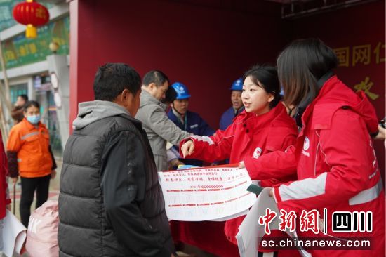服务站志愿者们正向返乡人员或居民发放安全用电宣传单。苟华彬 摄 服务站志愿者们正向返乡人员或居民发放安全用电宣传单。苟华彬 摄