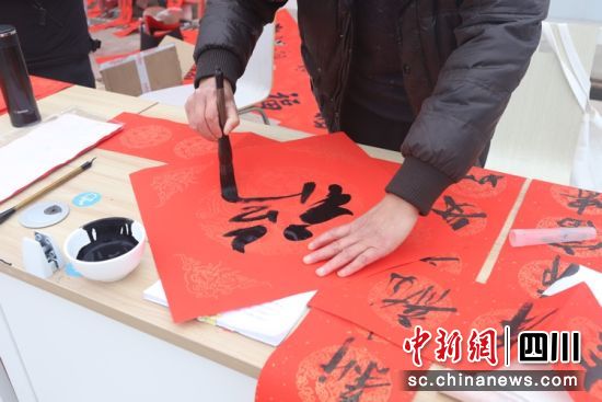为工友们写春联和“福”字。成都东部新区 供图 为工友们写春联和“福”字。成都东部新区 供图