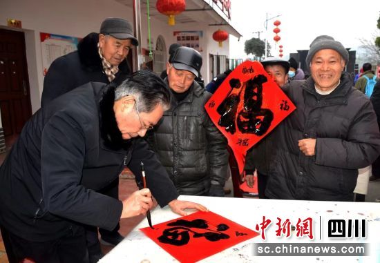书法家为群众写“福”字。 罗江区委宣传部供图 书法家为群众写“福”字。 罗江区委宣传部供图