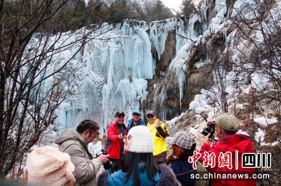 游客在冰瀑前拍照打卡。 平武县委宣传部供图 游客在冰瀑前拍照打卡。 平武县委宣传部供图