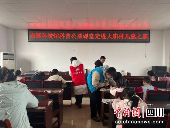 科技馆志愿者指导孩子们制作跷跷板。郑悦梅 摄 科技馆志愿者指导孩子们制作跷跷板。郑悦梅 摄