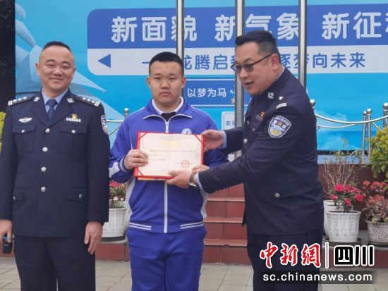 来自浙江省嘉兴市嘉善县公安局西塘派出所副所长庄叶锋为成都市锦西中学校2024届四班学生谢柯江颁发了荣誉证书。潘欢欢 摄 来自浙江省嘉兴市嘉善县公安局西塘派出所副所长庄叶锋为成都市锦西中学校2024届四班学生谢柯江颁发了荣誉证书。潘欢欢 摄