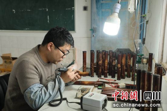 工作人员雕刻竹香筒。朱思雨 摄 工作人员雕刻竹香筒。朱思雨 摄