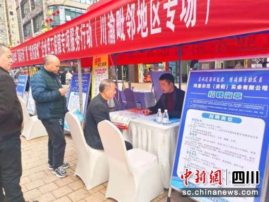 求职者正在现场了解。 闫凯 摄 求职者正在现场了解。 闫凯 摄