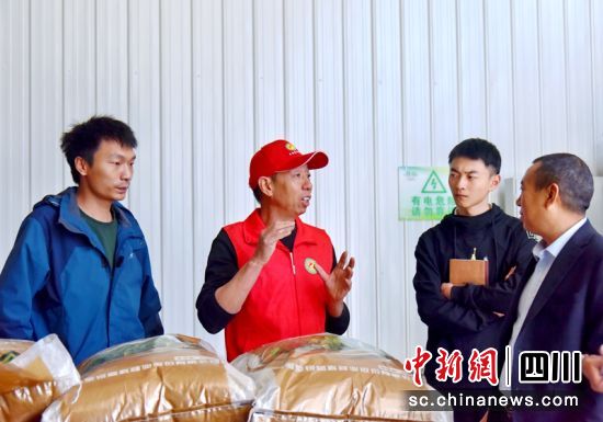农技员(左二)在水稻浸种现场指导。黄思梅 摄 农技员(左二)在水稻浸种现场指导。黄思梅 摄
