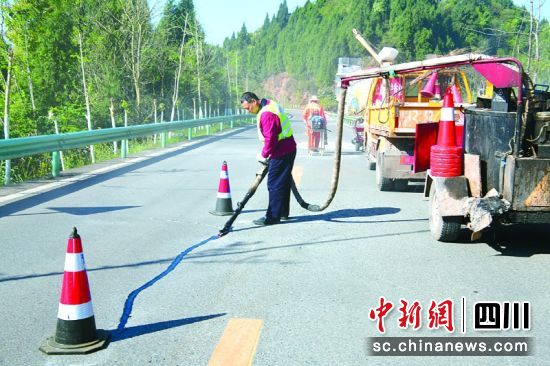 养护人员对有裂缝的路面进行修补。彭杰 摄 养护人员对有裂缝的路面进行修补。彭杰 摄