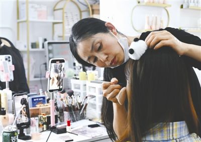 吕柳正在给顾客化妆,并进行直播 吕柳正在给顾客化妆,并进行直播
