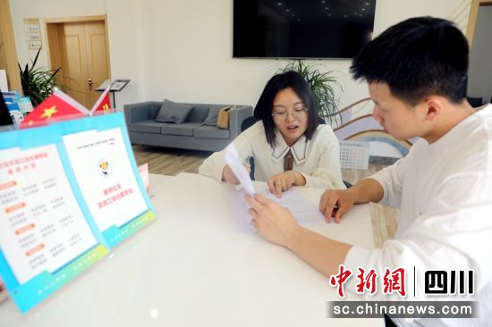 新桥社区农民工综合服务站里工作人员正在给余鹏介绍住房。程欢悦 摄 新桥社区农民工综合服务站里工作人员正在给余鹏介绍住房。程欢悦 摄