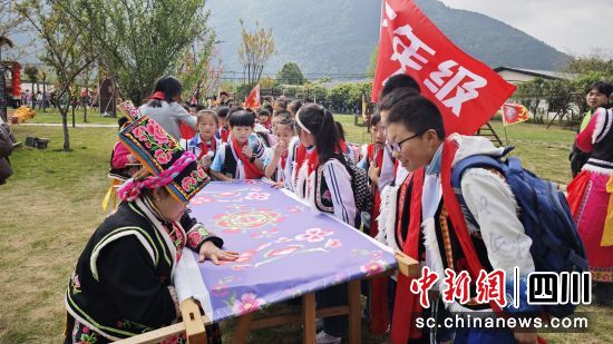 学生观摩羌绣非遗技艺。 北川县委宣传部供图 学生观摩羌绣非遗技艺。 北川县委宣传部供图