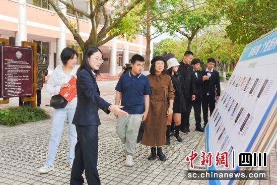 家长、学生观看校园展板。 郑伊琳 摄 家长、学生观看校园展板。 郑伊琳 摄