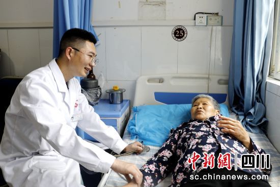 陈乾帮助群众诊治病情。王超明 摄 陈乾帮助群众诊治病情。王超明 摄