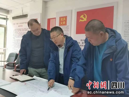 王远龙(中)与同事研究岗托水电站前期工作。受访者供图 王远龙(中)与同事研究岗托水电站前期工作。受访者供图