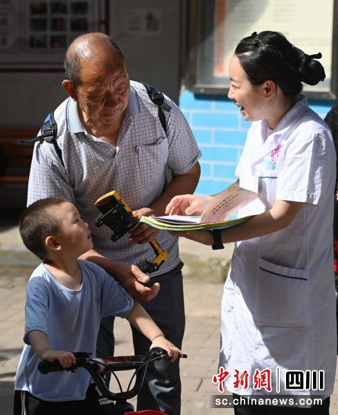 医务人员正在向群众宣传科学育儿知识。周亮 摄 医务人员正在向群众宣传科学育儿知识。周亮 摄