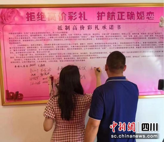 攀枝花市盐边县新人共同签署《抵制高价彩礼承诺书》。陈小平摄 攀枝花市盐边县新人共同签署《抵制高价彩礼承诺书》。陈小平摄