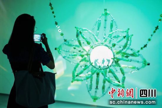 一位观众正在拍摄用垃圾“变身”而来的艺术作品。中国银联 供图 一位观众正在拍摄用垃圾“变身”而来的艺术作品。中国银联 供图