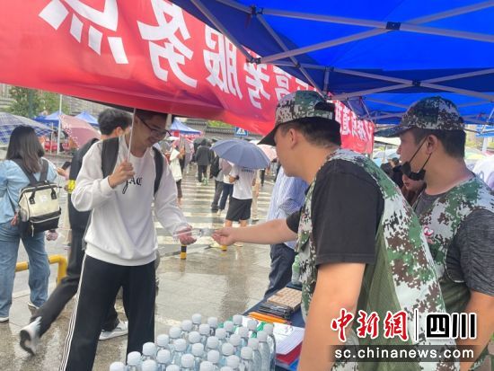 志愿队队员为考生发放饮用水。刘怡 摄 志愿队队员为考生发放饮用水。刘怡 摄