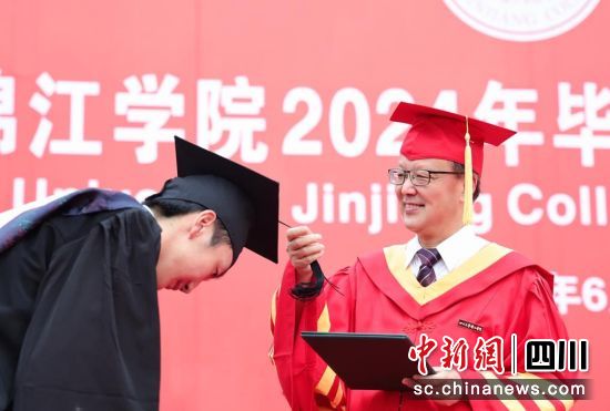 晏世经校长为毕业生代表拨穗正冠。 彭勇 摄 晏世经校长为毕业生代表拨穗正冠。 彭勇 摄