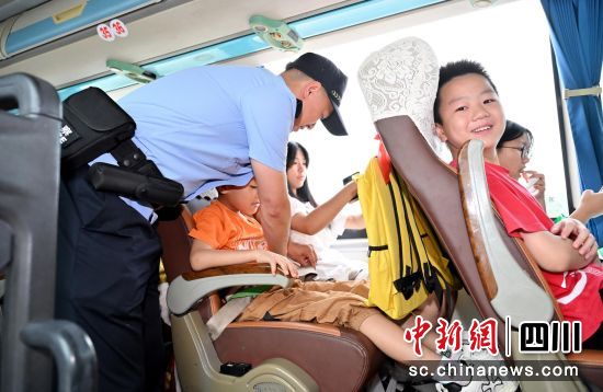 民警在逐一检查孩子们的安全带。四川公安供图 民警在逐一检查孩子们的安全带。四川公安供图