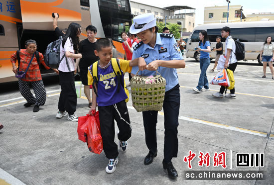 东莞市大朗镇公安分局接站民警帮助小乘客拿行李。四川公安供图 东莞市大朗镇公安分局接站民警帮助小乘客拿行李。四川公安供图