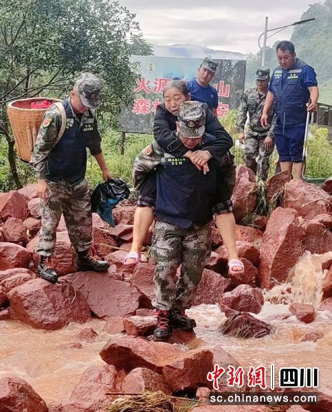 救援人员背着老人转移并通过垮塌路段。乐山应急供图 救援人员背着老人转移并通过垮塌路段。乐山应急供图