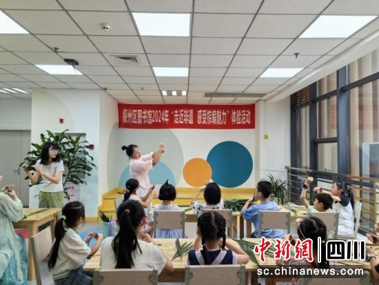 叙州区编织工艺大师黄思宜正在指导孩子们制作棕编小鱼。龙怡 摄 叙州区编织工艺大师黄思宜正在指导孩子们制作棕编小鱼。龙怡 摄