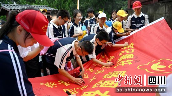 营员集体在营旗上签字。邹刚 摄 营员集体在营旗上签字。邹刚 摄