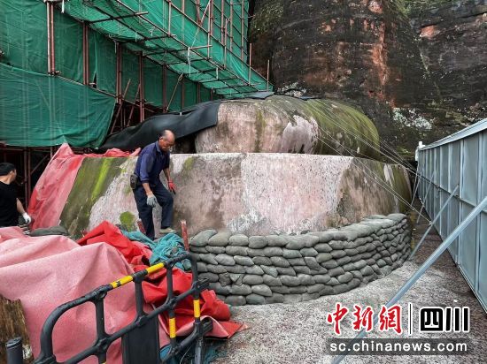 工人师傅用沙袋围住大佛脚周围,防止洪水冲击。乐山大佛景区供图 工人师傅用沙袋围住大佛脚周围,防止洪水冲击。乐山大佛景区供图