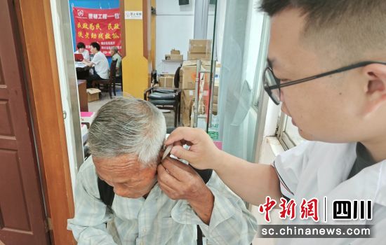 为老人安装助听器。贡井融媒 供图 为老人安装助听器。贡井融媒 供图
