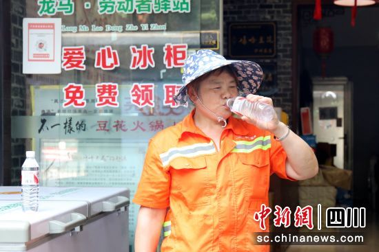 环卫工在爱心冰柜前喝水。谢汶萍 摄 环卫工在爱心冰柜前喝水。谢汶萍 摄