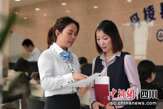 工作人员为办事市民答疑解惑。陈静 摄 工作人员为办事市民答疑解惑。陈静 摄