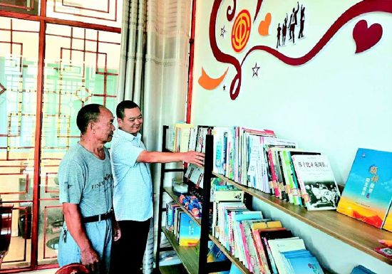 全国劳动模范杨华顺(左)在景区工会驿站书屋了解藏书情况 全国劳动模范杨华顺(左)在景区工会驿站书屋了解藏书情况