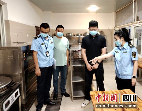 执法人员正在校园检查食堂。何鑫 摄 执法人员正在校园检查食堂。何鑫 摄