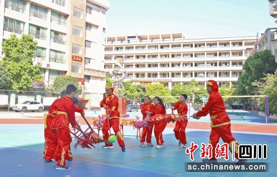 在西充县第一实验小学,祥龙板凳龙第十五代传承人李海东正在指导该校部分舞龙骨干老师和学生免费进行学习训练。廖桂华 摄 在西充县第一实验小学,祥龙板凳龙第十五代传承人李海东正在指导该校部分舞龙骨干老师和学生免费进行学习训练。廖桂华 摄