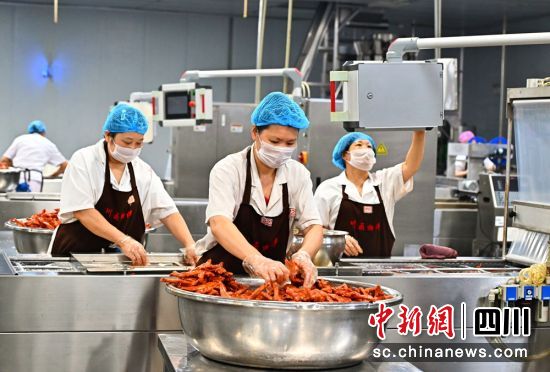 食品加工车间里工人师傅正忙着包装食品。潘帅 摄 食品加工车间里工人师傅正忙着包装食品。潘帅 摄
